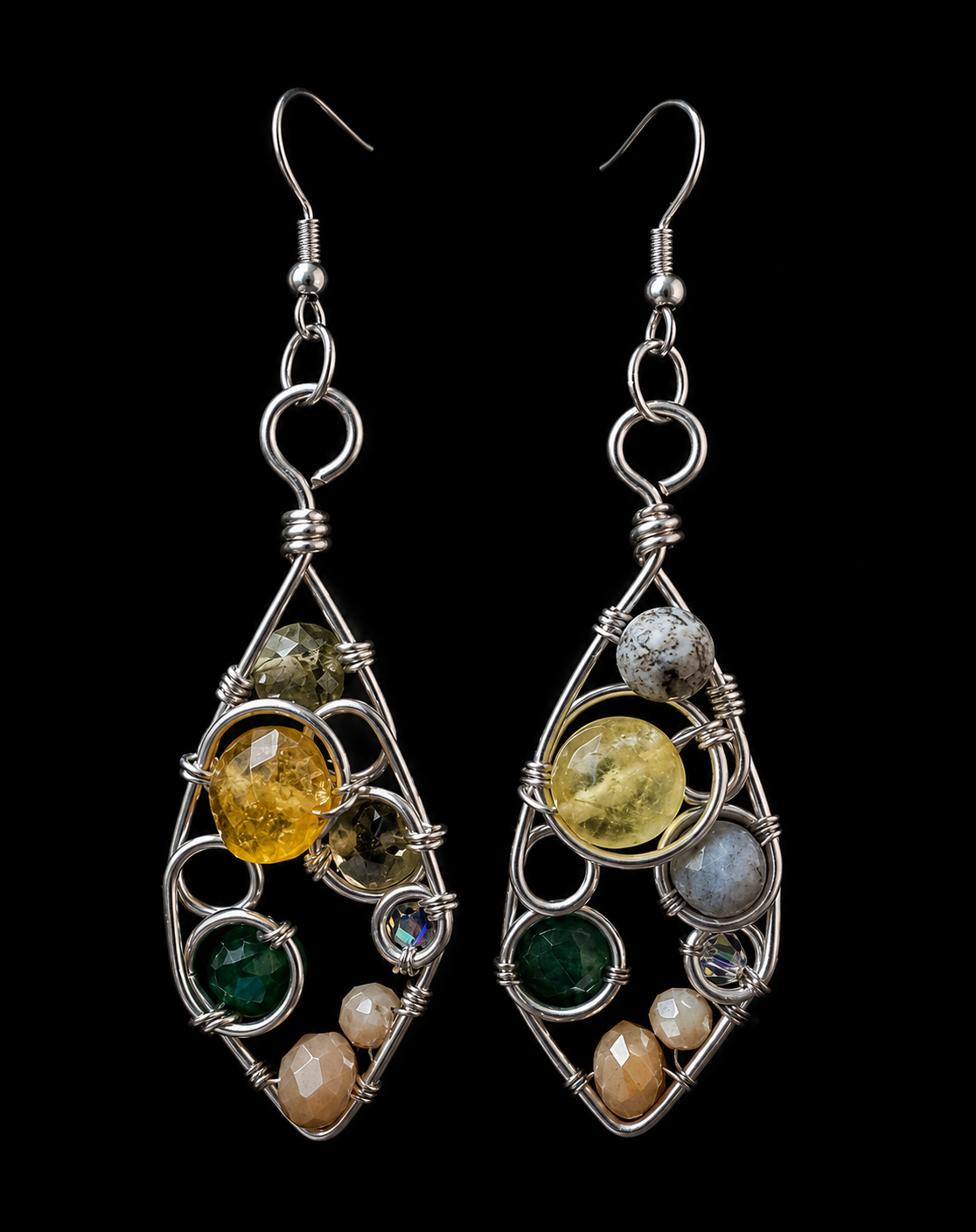 A pair of handmade dangle earrings with silver wire frames and multiple colorful gemstones, shown against a solid black background.
